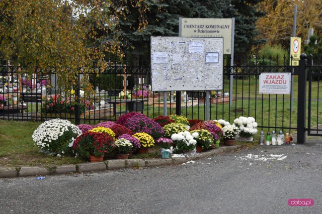 Kwiaty i znicze pod zamkniętym cmentarzami 