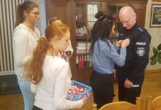 Młodzież obdarowała zastępcę Komendanta Powiatowego Policji kotylionem