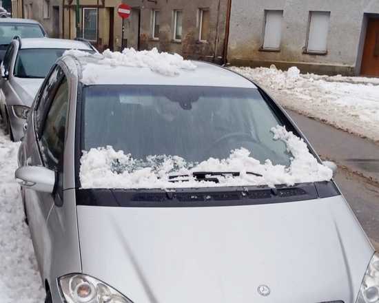 Śnieg i lód spadające z dachów uszkodziły dwa samochody